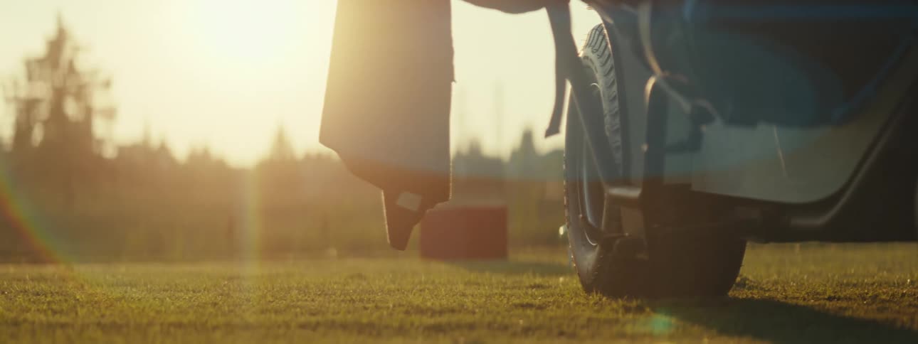 A golf cart moves around on a grass field