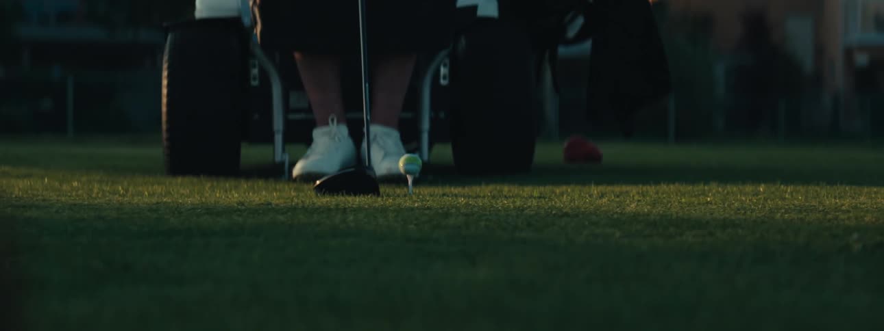 A person hits the golf ball with the club