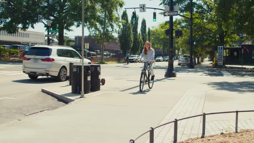 Young woman riding a bicycle on the sidewalk of a metropolis