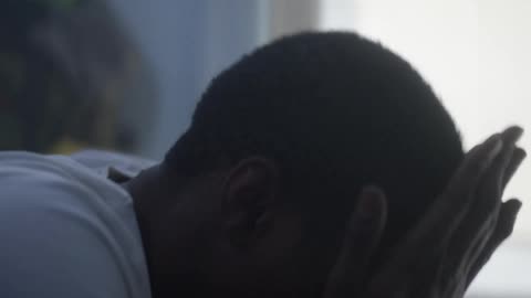 A boy gets out of bed seemingly in pain
