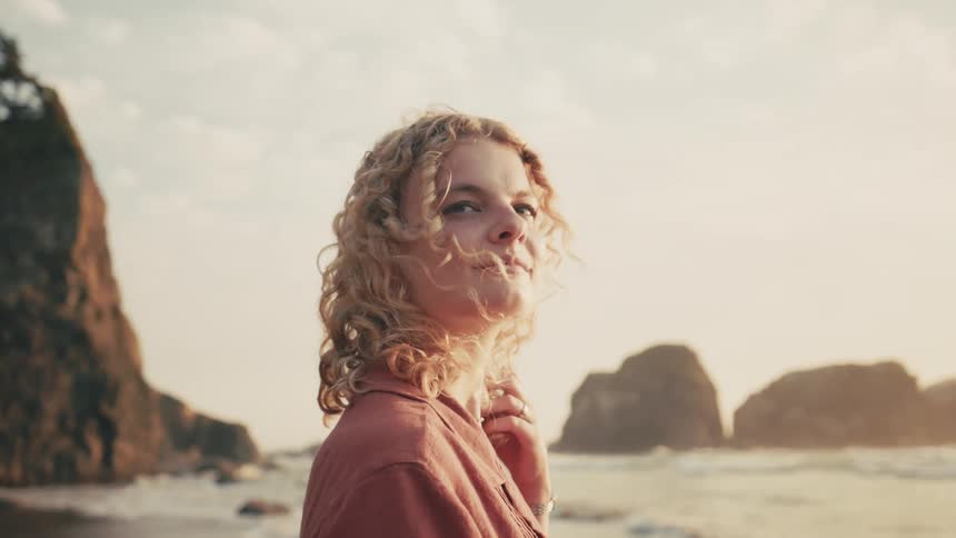 Blonde woman with curly hair on the beach