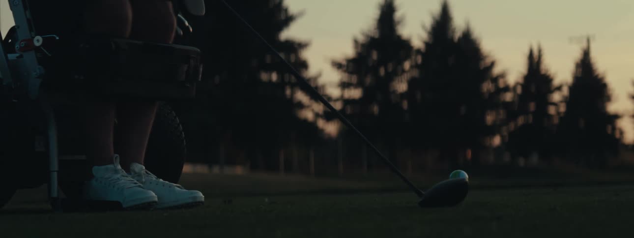Silhouette of a persons legs holding a club and playing golf in the late afternoon