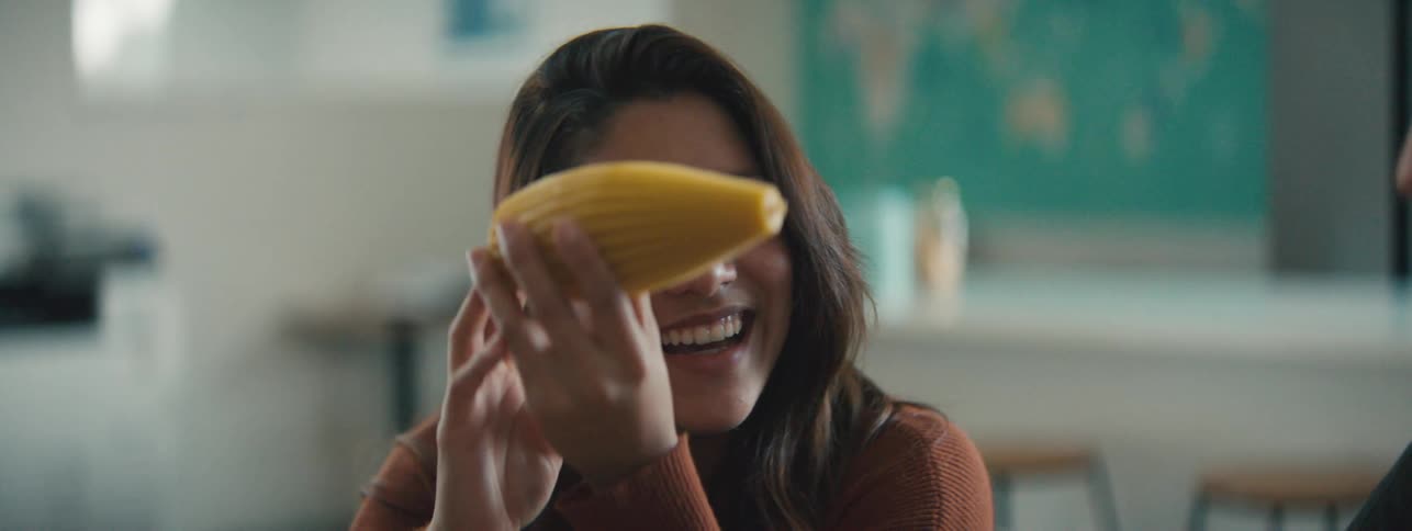 Woman smiles while examining a yellow object in an office