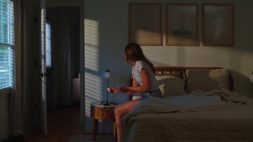 A woman wakes up and gets out of bed