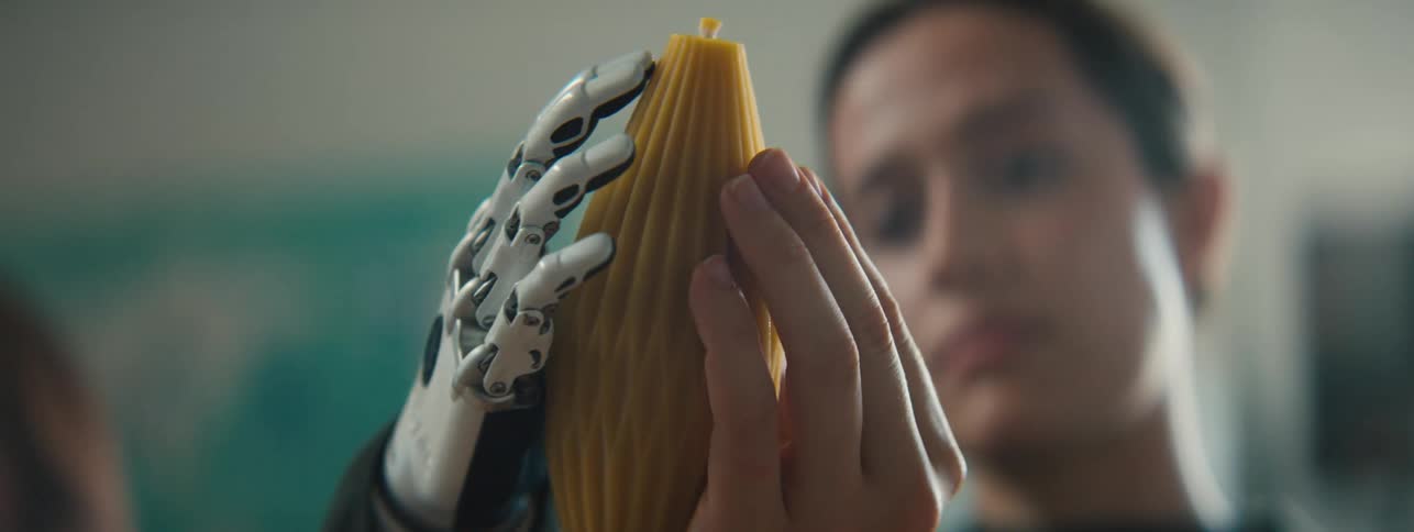 A woman is holding an object with her prosthetic hand