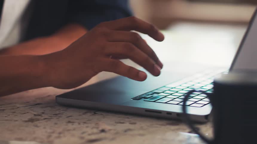 Hand typing on a laptop on the table