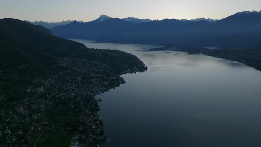 Aerial panorama in a morning sky with a city in the background surrounded by mountains and the edge of a lake