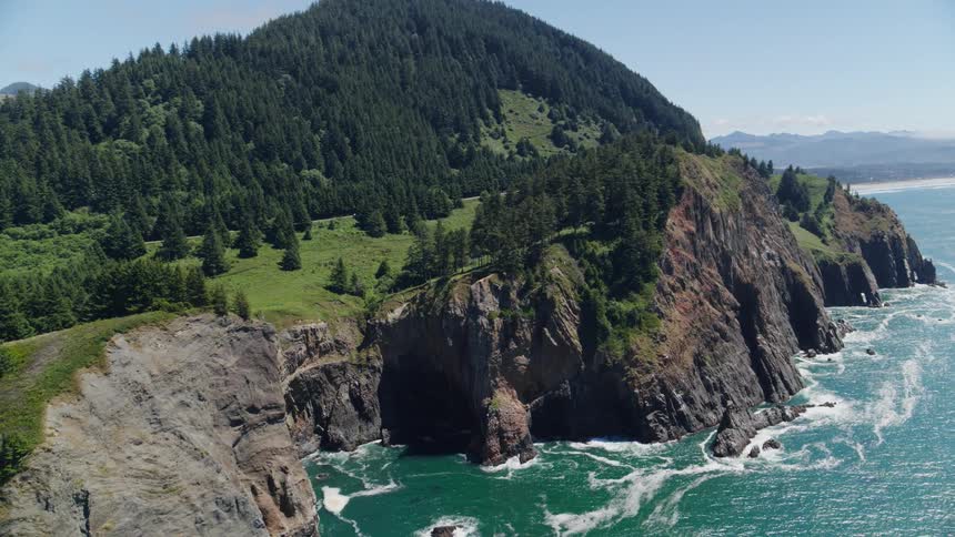 Mountain with conifers and cliffs by the sea