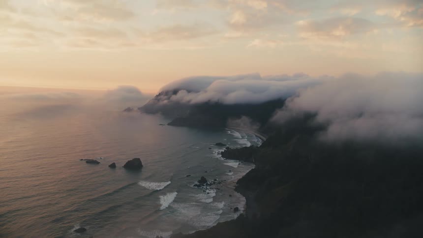 Aerial landscape of low clouds on rocky seaside coast