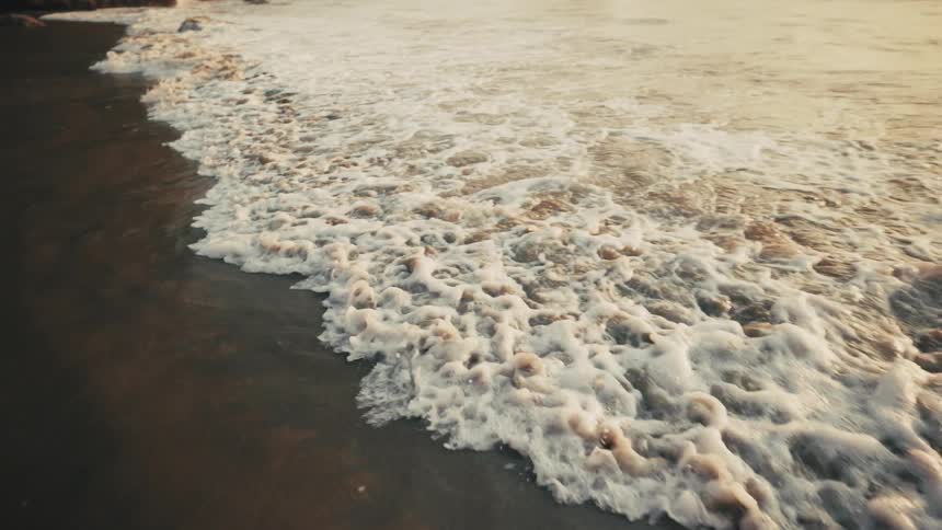 Ocean waves hitting a sandy beach