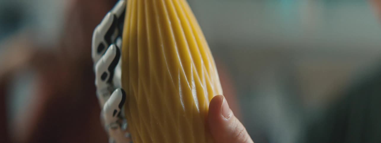 Robotic hand holding an abstract yellow object