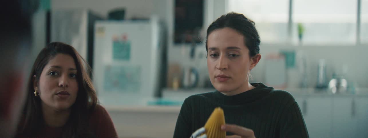 A woman with a prosthetic hand holding a 3d printed model on a well lit office