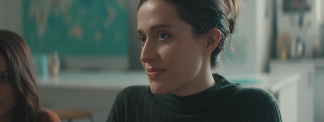 A close up of the face of a woman listening to an explanation in a well lit classroom
