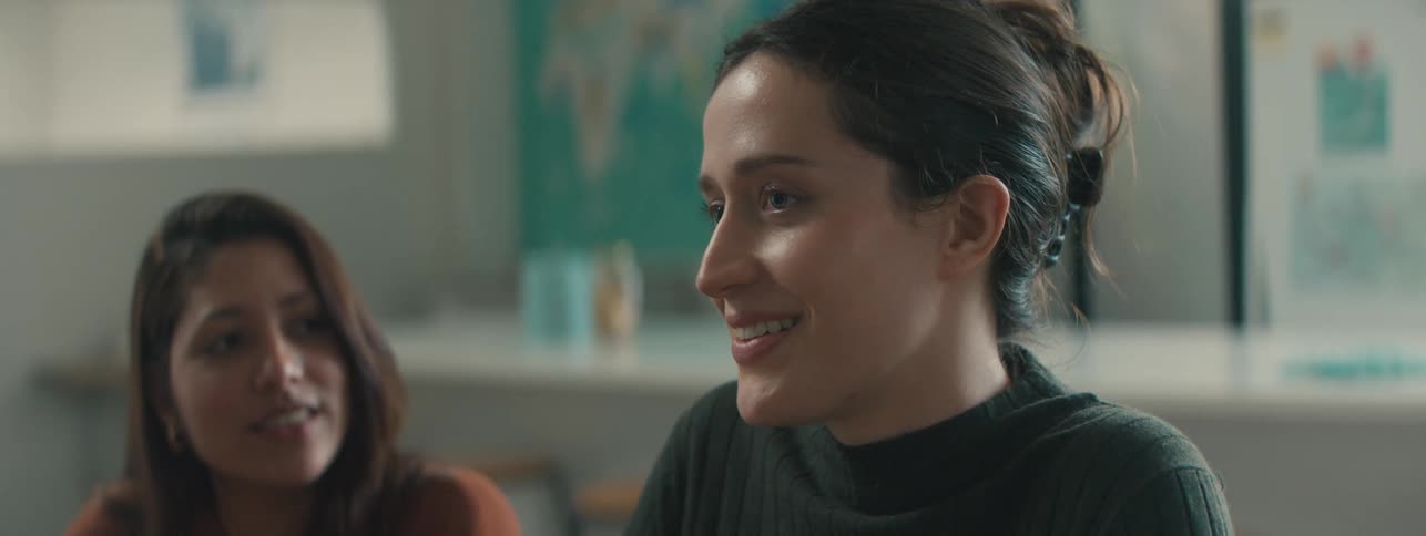 Two women sitting with happy facial expressions talking
