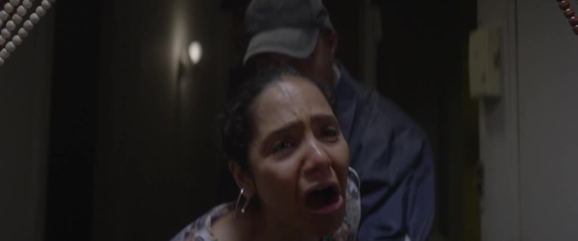 A woman is crying as she is being taken away by the police