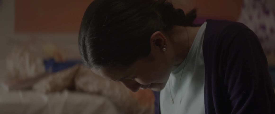 A woman begins to sob lowering her head