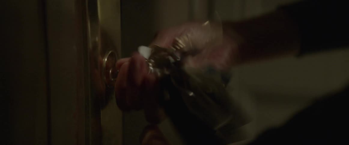 A person puts a key in their door and opens it