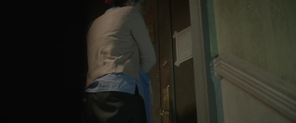 Woman pushing at a door in an apartment building