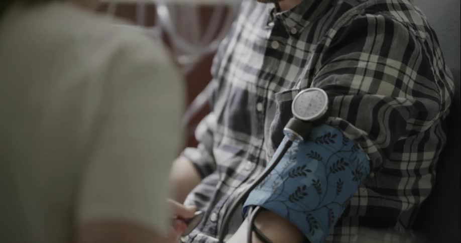 A nurse monitors a mans blood pressure