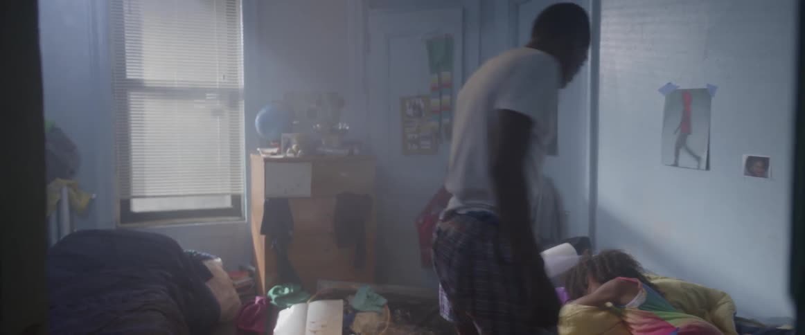 A boy getting out of bed and waking up a girl