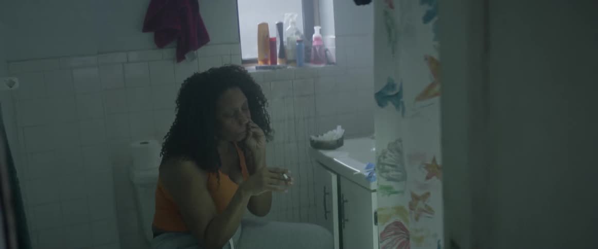A woman smokes a cigarette in the bathroom