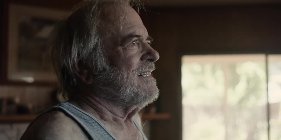 Portrait of an elderly man indoors giving a smile