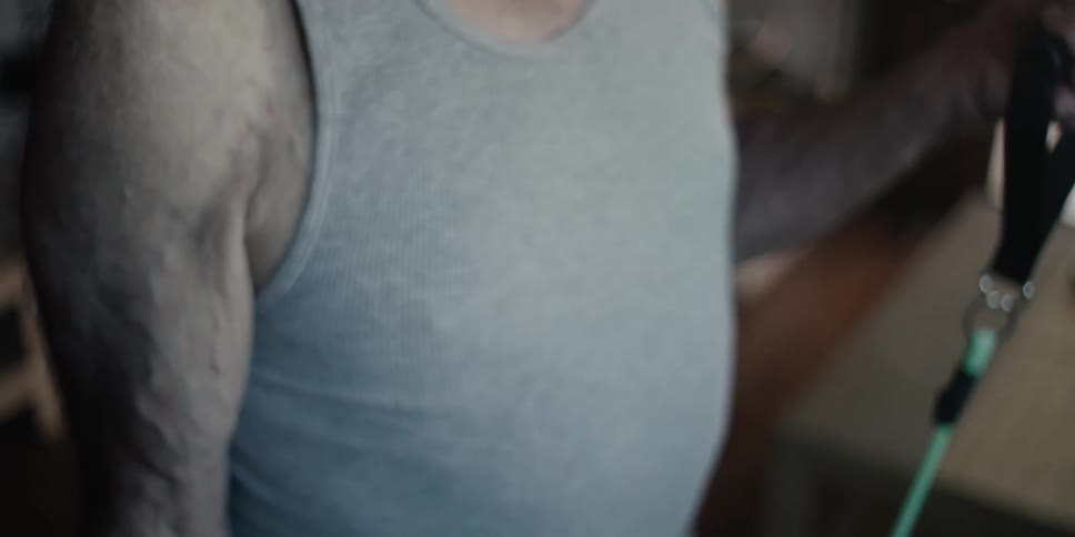 A mans hands pulling resistance bands focusing on the muscles and tendons in his arm as he exercises