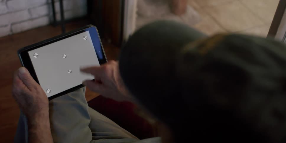 Hand of an elderly man sitting down using a tablet