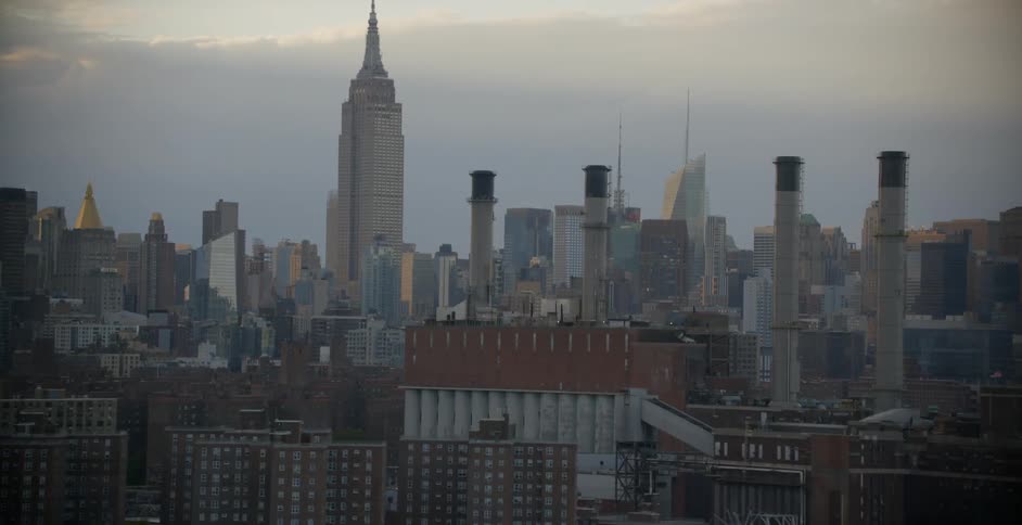 A large city stretches out beneath clouds during the day