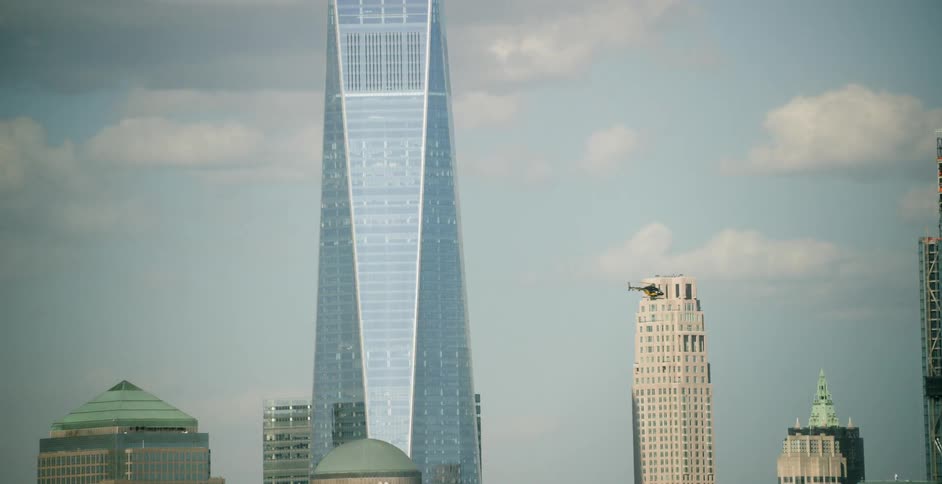 A helicopter flies past a tall skyscraper