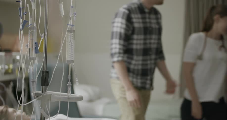 Man and woman in a hospital room get up and walk away together