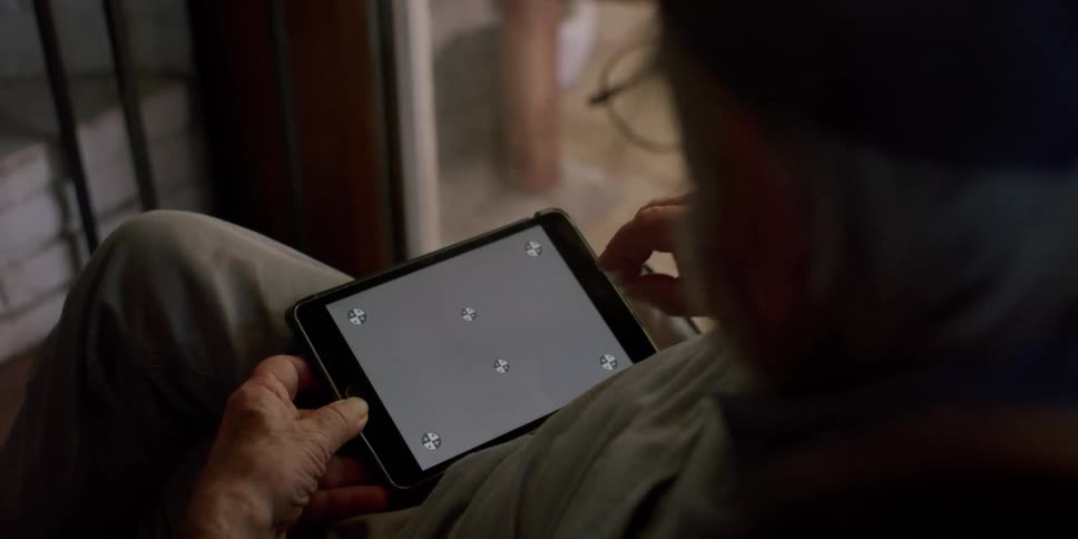Elderly man sitting in an armchair using a tablet