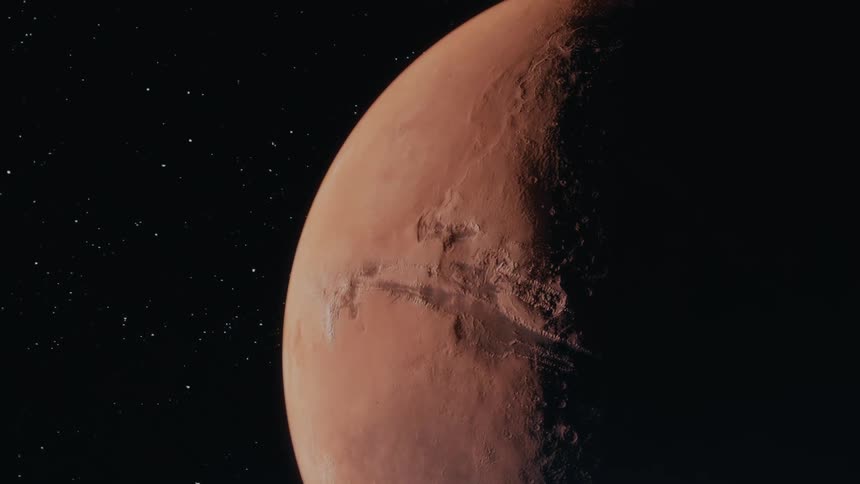 Reddish and brownish planet visible from space with stars and darkness in the background
