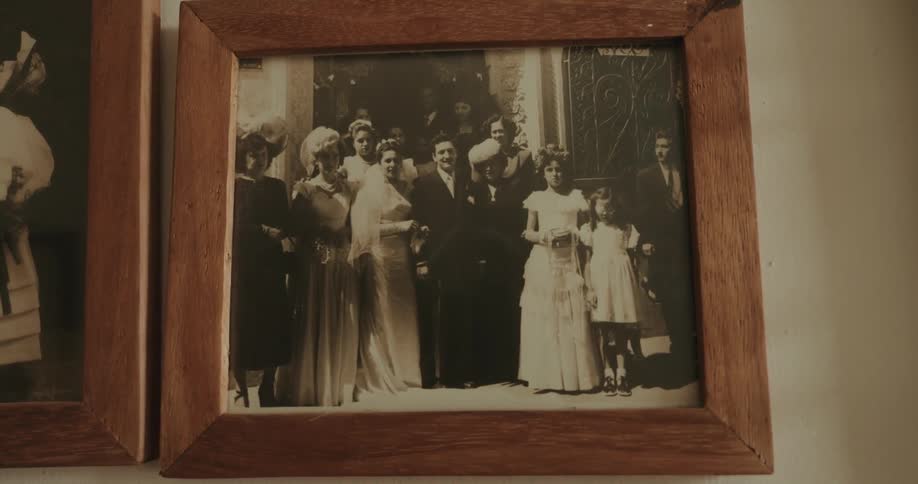 An old framed photograph of a family at a wedding hanging on a wall