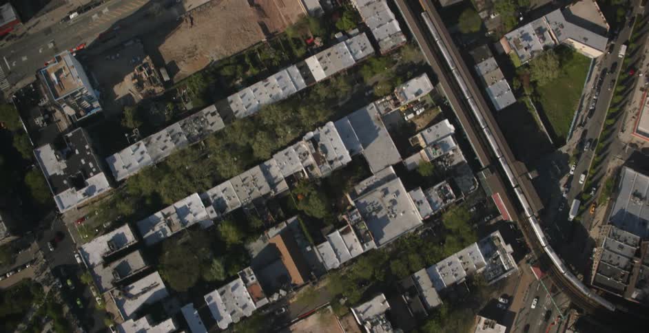 Cars drive through a city on a sunny day