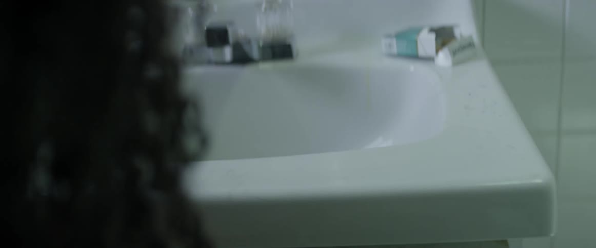 A woman pushes a needle and lighter in the sink