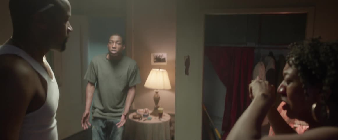 A man and woman are physically fighting when their teenage son comes into the room and stops it