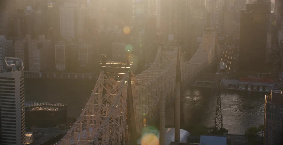 View of a large city next to a body of water with a bridge over it