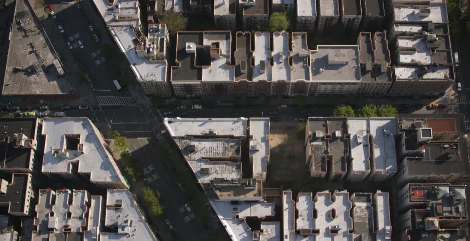 Cars drive through a city on a sunny day