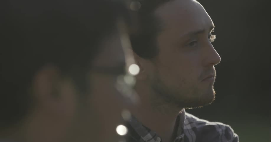 Two men stare outside on a sunny day