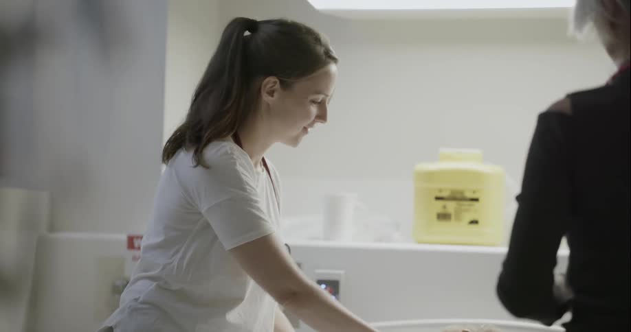A nurse tends to a patient in a hospital bed
