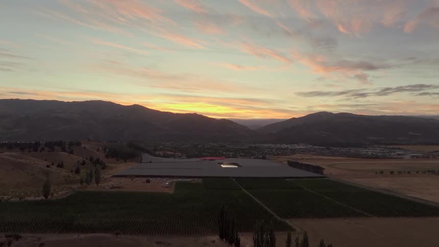 Aerial panorama on an agricultural field with mountains and town in the background