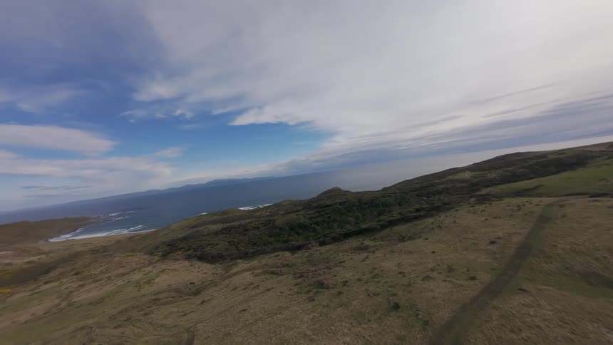 Long FPV flight from fields lead to the shore with blue ocean