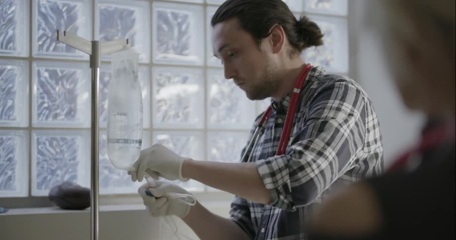 A male nurse prepares an iv bag