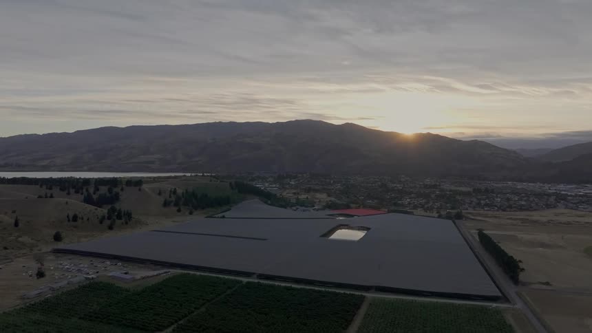 Aerial view of a nature reserve in an environment surrounded by vegetation with a town and sunrise in the distance