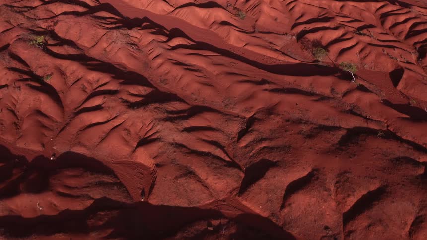 Aerial panorama of red soil reliefs with sparse vegetation