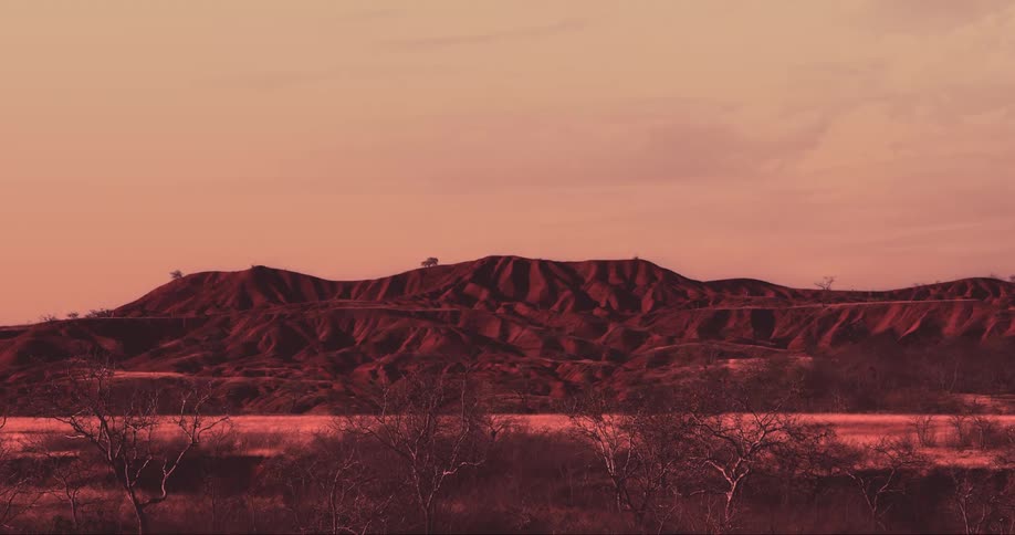 Mountain landscape in a desert environment with dry nature and a reddish sky
