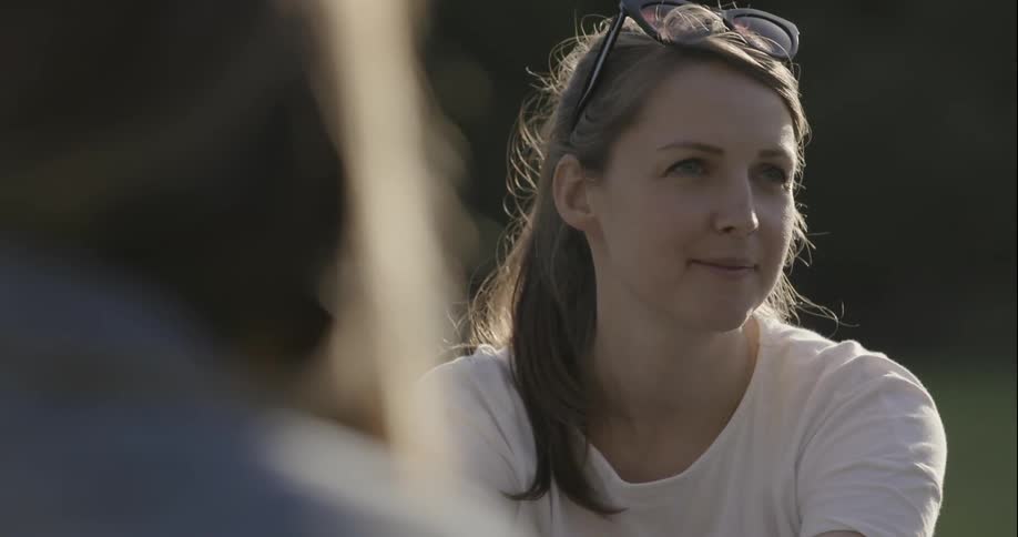 A woman talks outside with another person