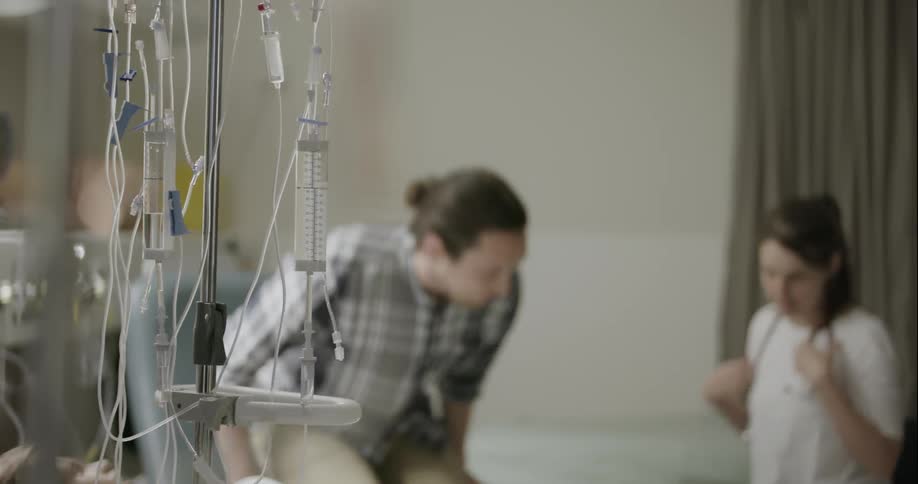 Man and a woman sitting in a medical area and the woman is wearing a stethoscope around her neck
