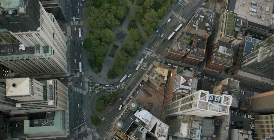 Cars ride along the streets in the city with tall buildings
